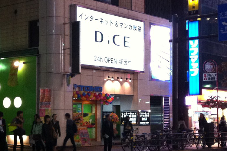 DICE池袋店入口の風景。夜の池袋の街に光り輝くDICEの看板の文字が目立ちます。